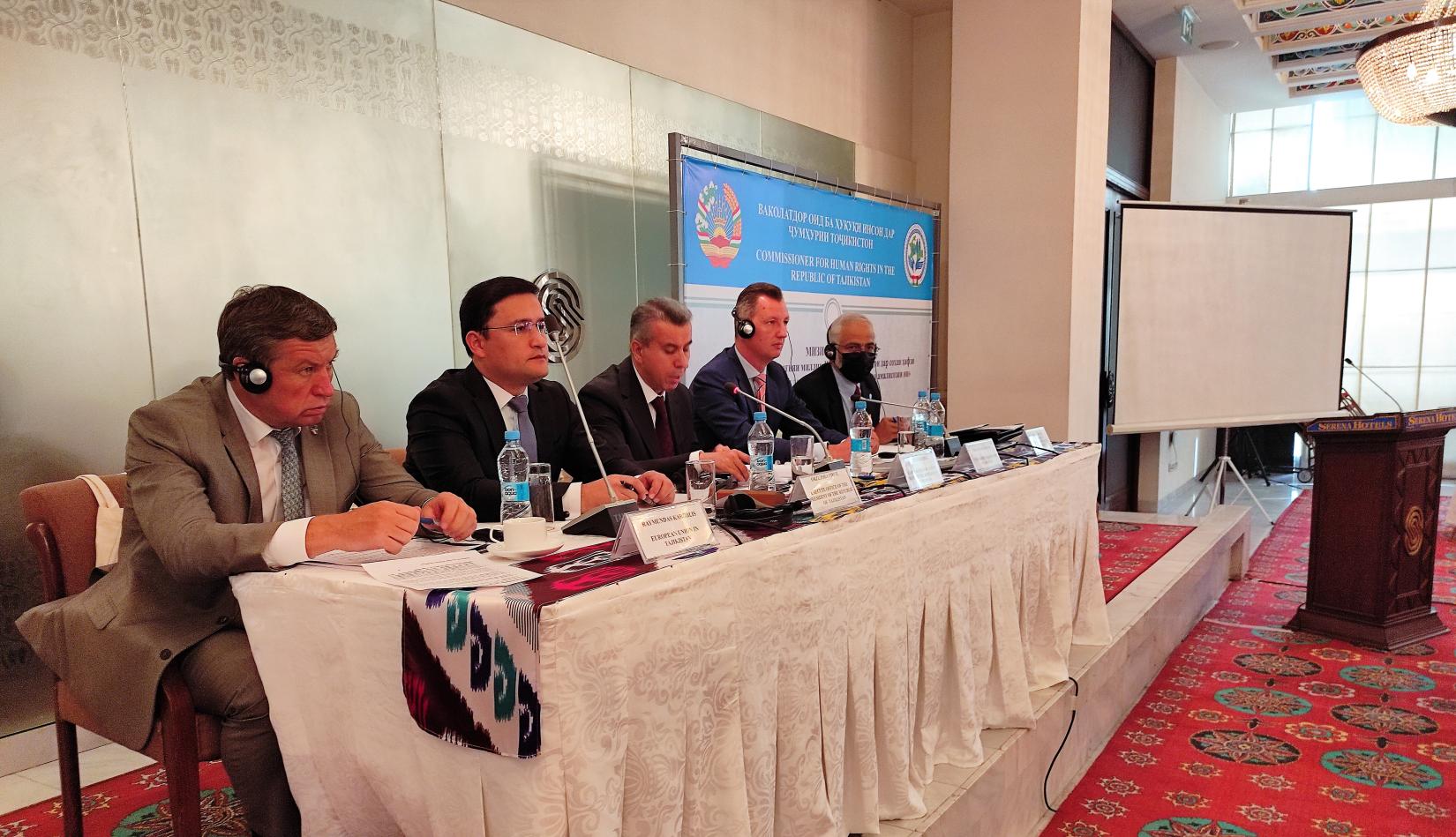 A group of speakers sitting at the table. A person makes a speech